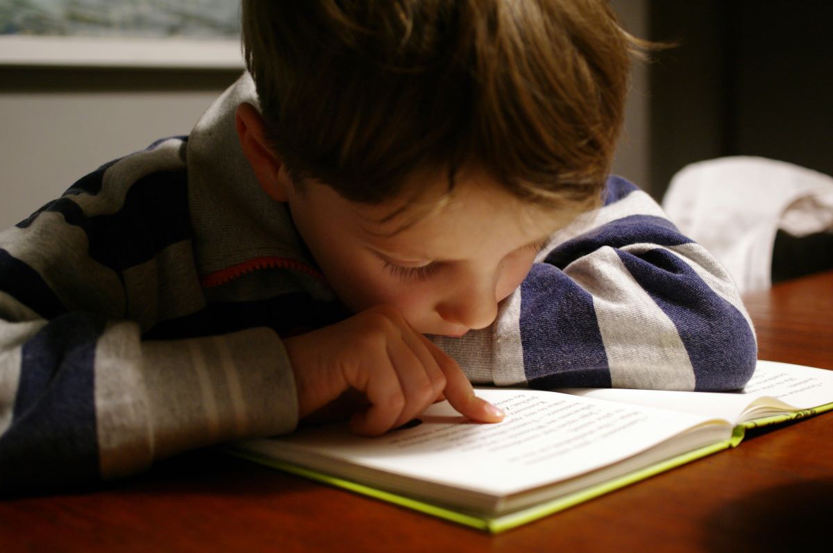 A child reading a book appropriate for his level of English, as it was selected with the Flesch Reading Ease score.